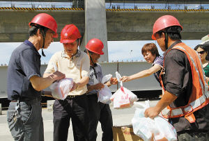昨天上午，在江北洪塘工地，电力工人收到了有关方面送来的防暑降温用品。