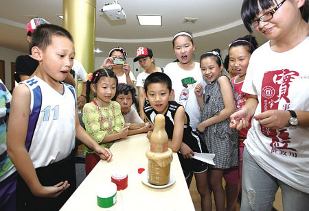 宁波大学材化学院学生给江东丹凤新村的孩子们做实验，宣传生活中的化学小知识