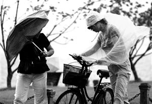 “潭美”也给杭州带来大雨，图为杭州市民走在西湖白堤