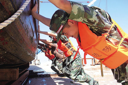  图为昨天舟山市东极边防派出所官兵帮助渔民将小型船舶转移上岸。（新华社发）