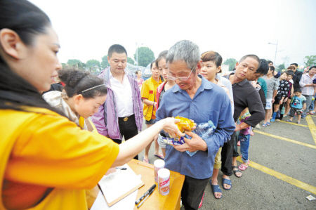 志愿者向受灾群众发放食物。 记者 崔引 摄