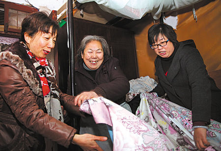 图为志愿者在给陈老太更换新床单。
